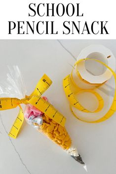 a tape measure and measuring tape on top of a table with the words school pencil snack