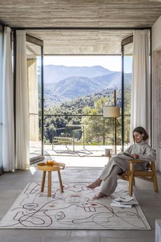 a woman sitting in a chair on top of a rug