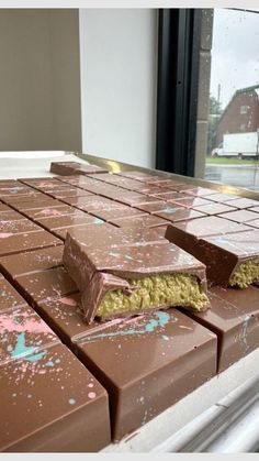 chocolate bars with sprinkles on them sitting on top of a window sill