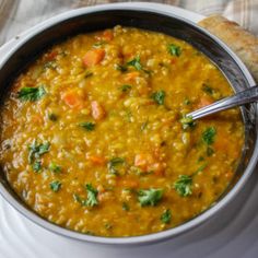 a black bowl filled with soup and garnished with cilantro