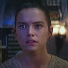 a woman with blue eyes stares at the camera while standing in front of a bar