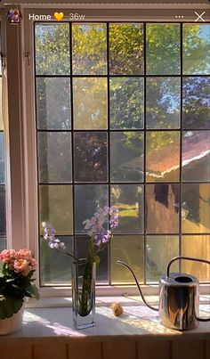 a window sill with flowers and watering can on it