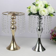 two vases with flowers in them sitting on a table next to eachother