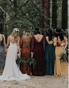 a group of women standing next to each other in front of some tall trees and greenery