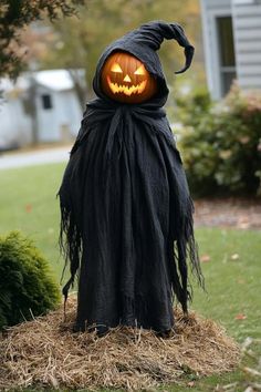 a halloween pumpkin head is on top of a hay bale