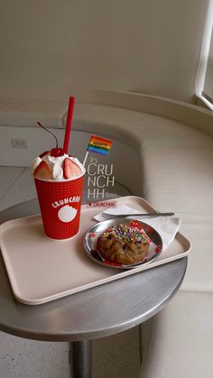 a tray with a cup of ice cream and a cookie on it next to a box of dunkin donuts