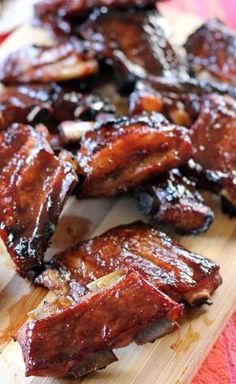 barbecue ribs on a wooden cutting board with bbq sauce