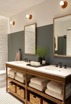 a bathroom with two sinks, mirrors and towels on the rack in front of it