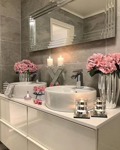 a bathroom with a sink, mirror and candles on the counter in front of it