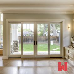 an empty room with sliding glass doors and wood flooring in the center is shown