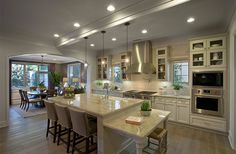 a large kitchen with an island in the middle and two ovens on each side