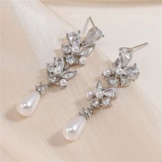 Step Into A World Of Delicate Elegance With Our Floral Frost Pearl Dangle Earrings. These Enchanting Earrings Capture The Ethereal Beauty Of Frost-Kissed Blossoms. Each Earring Features An Intricately Designed Floral Motif, Resplendent With A Luminous Pearl That Mirrors The Purity Of Glistening Frost On Petals. These Earrings Are A Wearable Masterpiece That Allows You To Carry The Serenity Of Winter's Charm With You. These Earrings Are Crafted With Meticulous Attention To Detail, Showcasing The Pearl Dangle Earrings Wedding, Silver Jewelry Fashion, Pearl Earrings Dangle, Ethereal Beauty, Accessories Jewelry Earrings, Women Accessories Jewelry, Silver Pearls, Women's Accessories, Jewelry Accessories