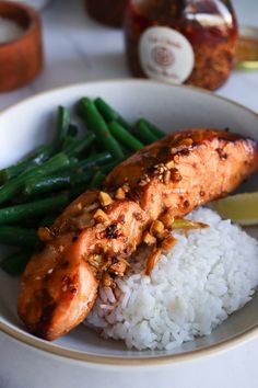 a plate with rice, green beans and some kind of meat on top of it