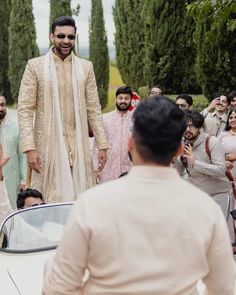 a man standing in front of a car surrounded by people