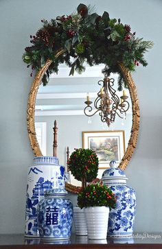 blue and white vases are sitting on a table in front of a round mirror