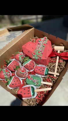 a box filled with lots of red and green decorated strawberries on top of a table