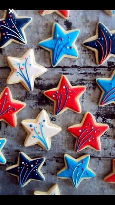 decorated cookies are arranged in rows on a wooden surface, with stars painted on them