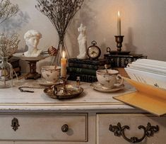 a table topped with lots of books and candles