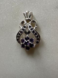 This handmade 925 sterling silver pendant is Heart shaped with Purple CZ Cubic Zircon . Pendant Height : 2.7 cm(approx) Pendant Width : 1.7 cm(approx) Pendant Weight : 4.70 grams(approx) Stone Colour : Purple Large Round Stone Center Flower Pattern  : 3mm(approx) Small Round Stone                                           :1.5mm Best Quality Guaranteed Why to wear silver? As a metal, silver has significant health benefits that have been used across cultures for centuries. Silver has a proven tra Silver Cubic Zirconia Necklace With Stone Setting, Handmade Cubic Zirconia Pendant Jewelry, Silver Gemstone Round Pendant Jewelry, Sterling Silver Necklace With Accent Stones For Gift, Silver Necklaces With Accent Stones For Gifts, Silver Necklaces With Stone Setting As Gift, White Gold Sterling Silver Jewelry With Stone Setting, Silver Necklaces With Stone Setting Ideal As Gifts, Silver Necklace With Stone Setting For Gift