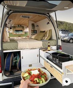 a person holding a bowl of food in the back of an rv