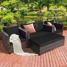 an outdoor furniture set on a deck with trees and water in the backround