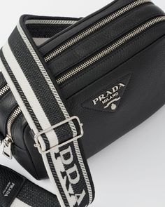 Two compartments Detachable 95 cm logo-print embroidered woven tape strap Detachable adjustable 110 cm leather shoulder strap Metal hardware Metal lettering logo on the front Zipper closure Nylon logo-print lining with patch pocket Leather Bag Strap With Leather Trim For Travel, Luxury Travel Bags With Logo Hardware, Luxury Travel Bag With Logo Hardware, Designer Leather Bag With Logo Strap, Modern Logo Bag Strap For Travel, Designer Leather Shoulder Bag With Logo Strap, Luxury Crossbody Bag With Logo Strap, Luxury Shoulder Bag With Logo Strap For Everyday Use, Luxury Travel Shoulder Bag With Logo Hardware