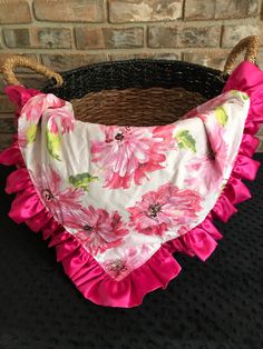 a pink flowered bib with ruffles hanging from it's sides