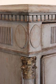 an old wooden cabinet with metal knobs on the top and bottom, painted white