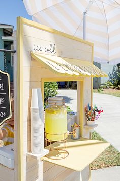 a small ice cream stand with an umbrella over it