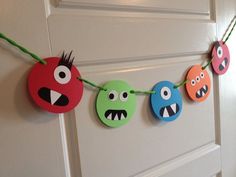 some paper cut outs are hanging on a door with eyes and mouths painted on them