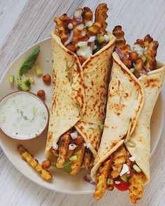 three quesadillas on a plate with dipping sauce