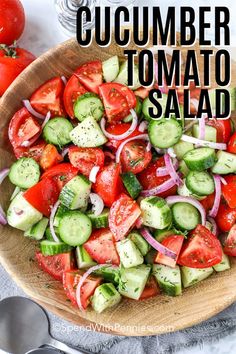 a wooden bowl filled with cucumber tomato salad