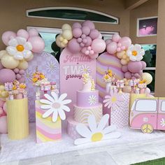 a pink and yellow birthday party with balloons, flowers, and cake on the table