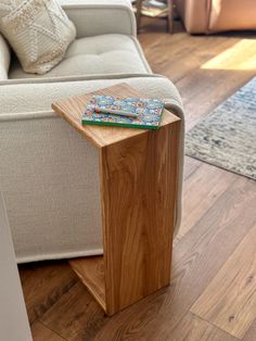 a wooden table sitting in front of a couch on top of a hard wood floor