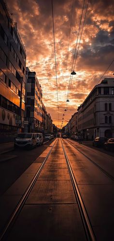 the sun is setting over an empty city street