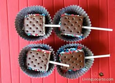 four chocolate pops are arranged on top of each other with toothpicks sticking out of them