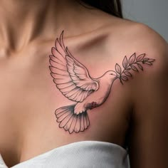 a woman with a tattoo on her chest has a white dove holding an olive branch