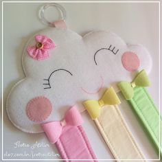 a white cloud with a pink bow hanging from it's side next to two clips