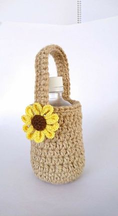 a crocheted bag with a sunflower on the side and a water bottle in it