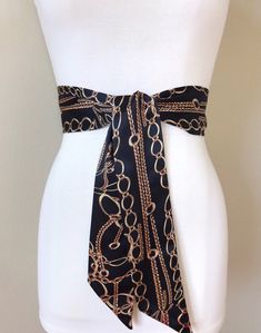 "Wide Black & Gold Chain Sash Belt Black and Gold Sash Gold Chain Link Belt Chain Link Sash Black and Gold Dress Sash Satin Swank Instantly update your jeans, dress, or top with this Satin Swank® black and gold chain print sash belt. Depending on your waist size and the length you choose (60, 75, and 90 inch lengths available), you can wrap this sash around your waist once or twice. You decide whether to tie the sash in a bow or a simple knot with long-hanging tails. Tie in front, in back, o Elegant Black Belt For Evening, Fitted Black Belts With Sashes, Black Chain Belt For Party, Elegant Black Belt For Night Out, Elegant Party Chain Belt With Chain Print, Elegant Chain Print Belt For Party, Elegant Party Chain Print Belt, Chic Black Chain Belt For Party, Chic Black Adjustable Chain Belt