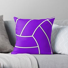 a purple and white throw pillow sitting on top of a couch