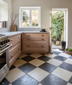 a kitchen with black and white checkered flooring next to an open door way