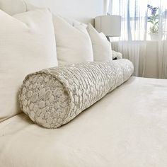 a rolled up mattress on top of a white bed