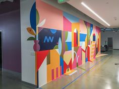 an office hallway with colorful artwork on the wall