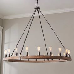 a wooden chandelier with many lights hanging from it's center beam in a living room