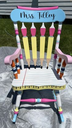 a child's rocking chair with crayons on it and the name mrs tilley