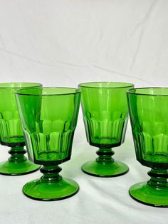 four green glass cups sitting on top of each other