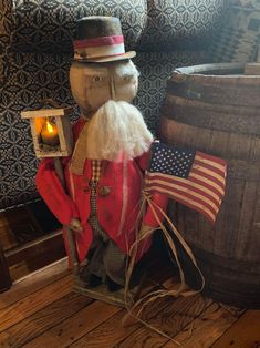 a large wooden bear sitting next to a barrel with an american flag on it's back