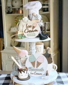 a three tiered cake stand with ice cream cones and other desserts on it