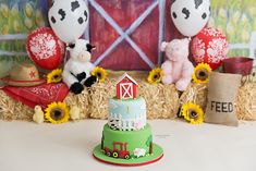 there is a cake with animals on it and hay bales around the cake are sunflowers